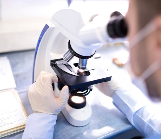Man using microscope for clinical research