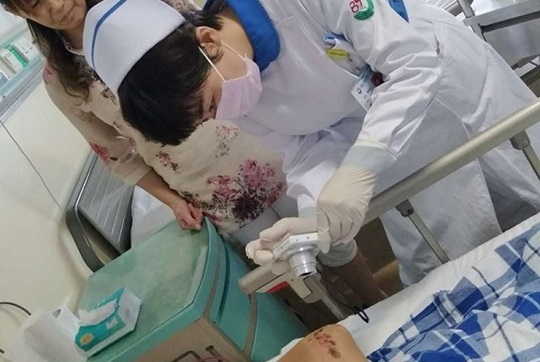 Huo Jizhen taking photos of a patient’s wound. 