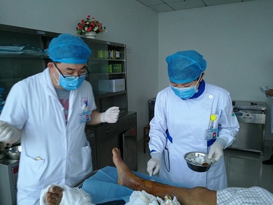 Huo Jizhen treating a patient’s wound together with a doctor.