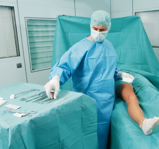 A doctor prepares the surgery of a leg wound.