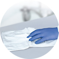 Hand in blauen Handschuhen putz Oberfläche mit Bacillol