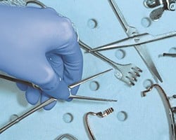 Detail ruky s chirurgickými nástrojmi v priebehu procesu dekontaminácie