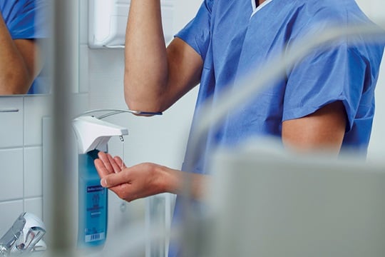 A nurse disinfects his hands in the hospital.