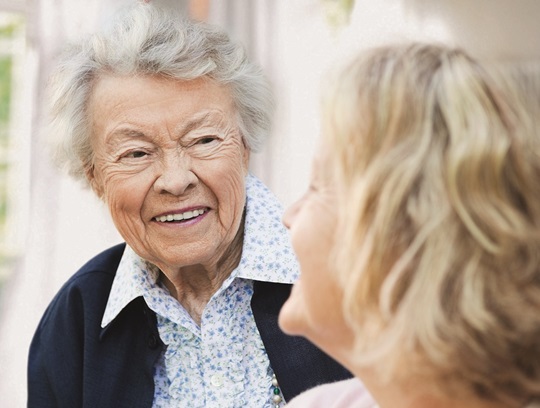 two old women talking with each other smiling