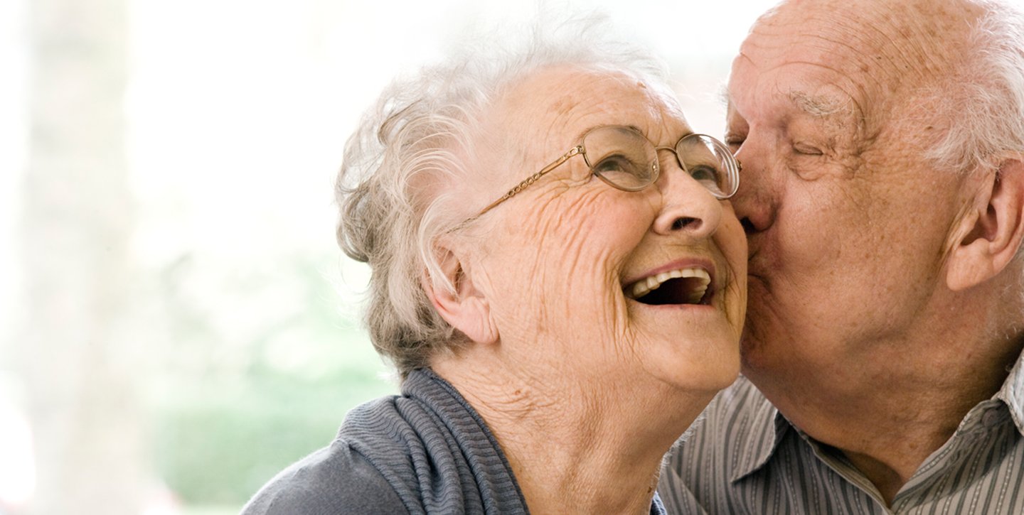 un abuelo besando a una abuela en la mejilla
